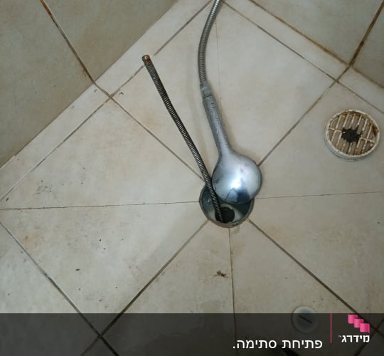 נחשול אינסטלציה בתוך חור ניקוז במקלחת